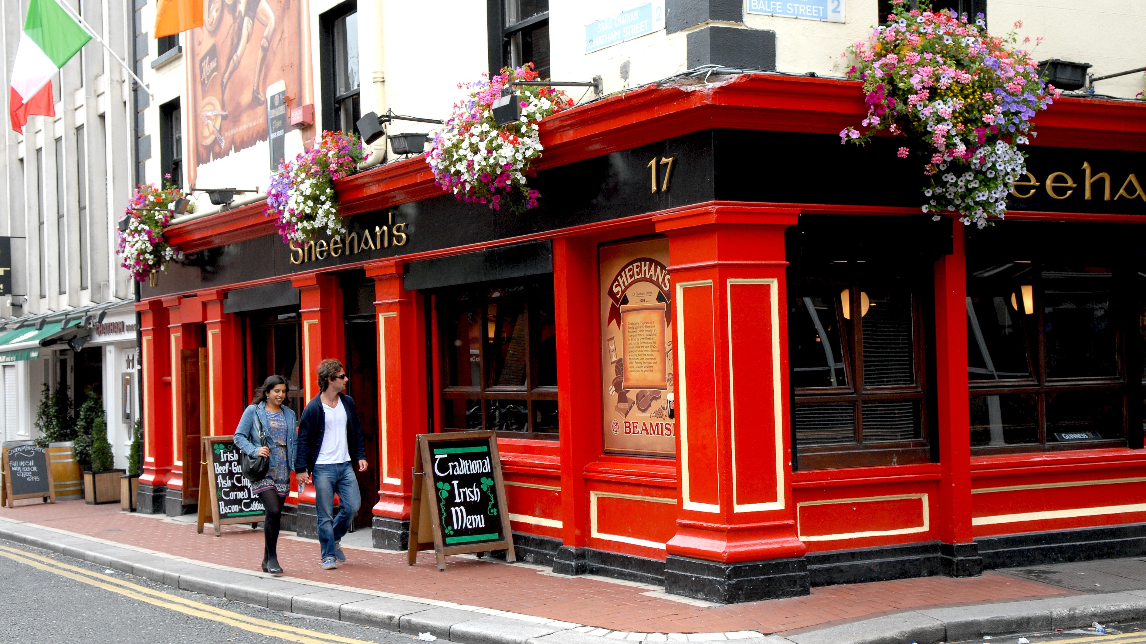 A warm Dublin pub interior with wooden tables, a bar, and traditional fittings
